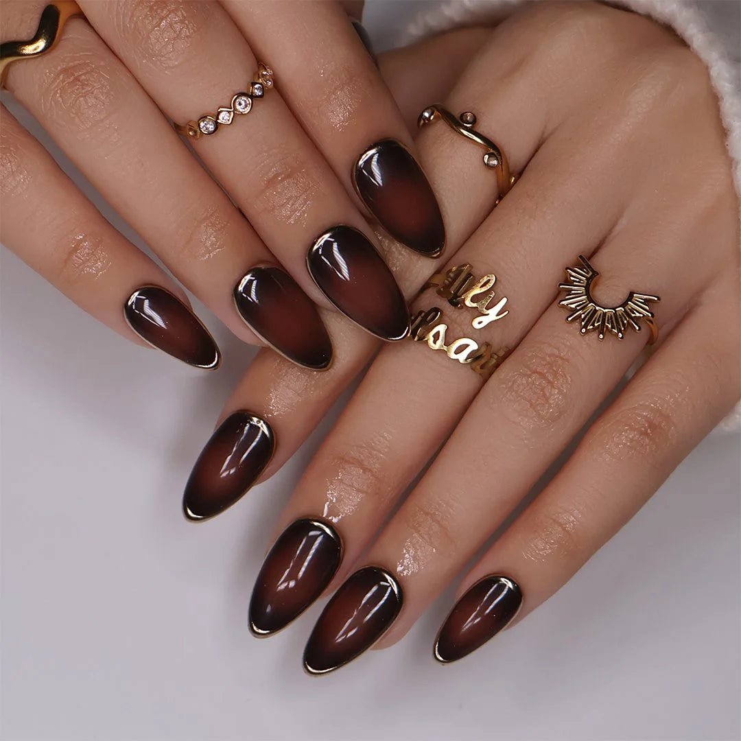 Espresso handmade fall press-on nails — almond set in glossy translucent chocolate-brown with liquid gold chrome mirror borders and a minimalist luxury finish