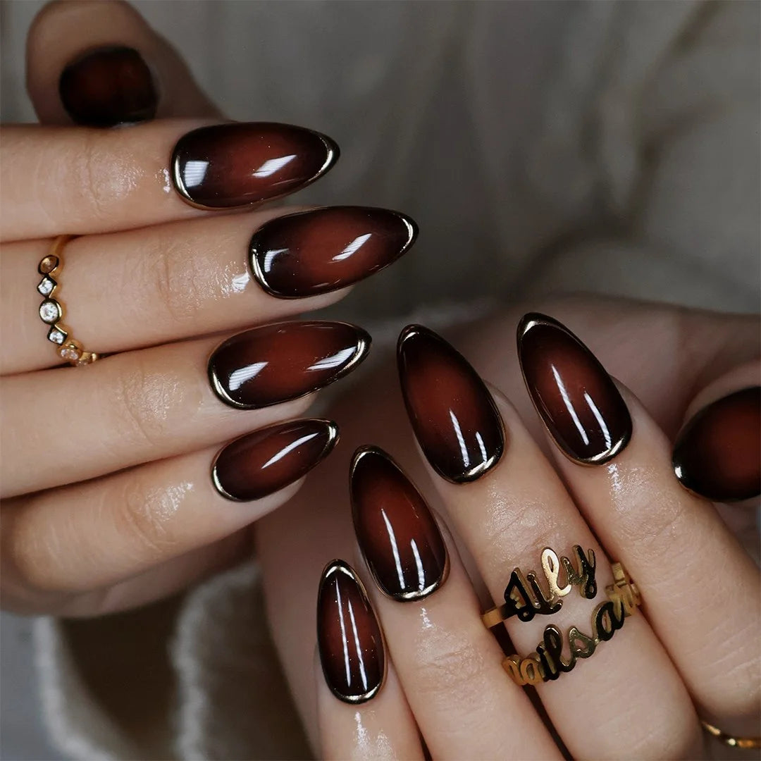 Espresso handmade fall press-on nails — almond set in glossy translucent chocolate-brown with liquid gold chrome mirror borders and a minimalist luxury finish