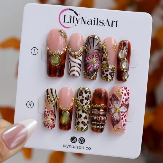 Zinfandel handmade fall press-on nails — maximalist long square set in nude, tortoiseshell and cream with 3D red-and-white orchids, olive and gold cat-eye cabochons, leopard and zebra prints, gold chains and pearl accents.