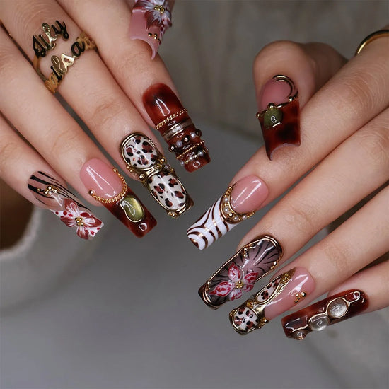 Zinfandel handmade fall press-on nails — maximalist long square set in nude, tortoiseshell and cream with 3D red-and-white orchids, olive and gold cat-eye cabochons, leopard and zebra prints, gold chains and pearl accents.