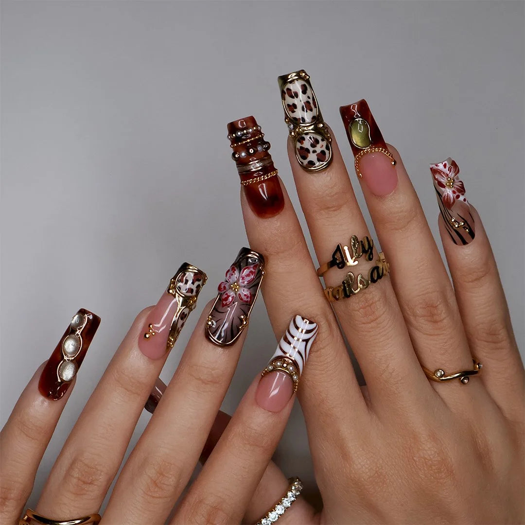 Zinfandel handmade fall press-on nails — maximalist long square set in nude, tortoiseshell and cream with 3D red-and-white orchids, olive and gold cat-eye cabochons, leopard and zebra prints, gold chains and pearl accents.