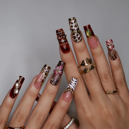 Zinfandel handmade fall press-on nails — maximalist long square set in nude, tortoiseshell and cream with 3D red-and-white orchids, olive and gold cat-eye cabochons, leopard and zebra prints, gold chains and pearl accents.
