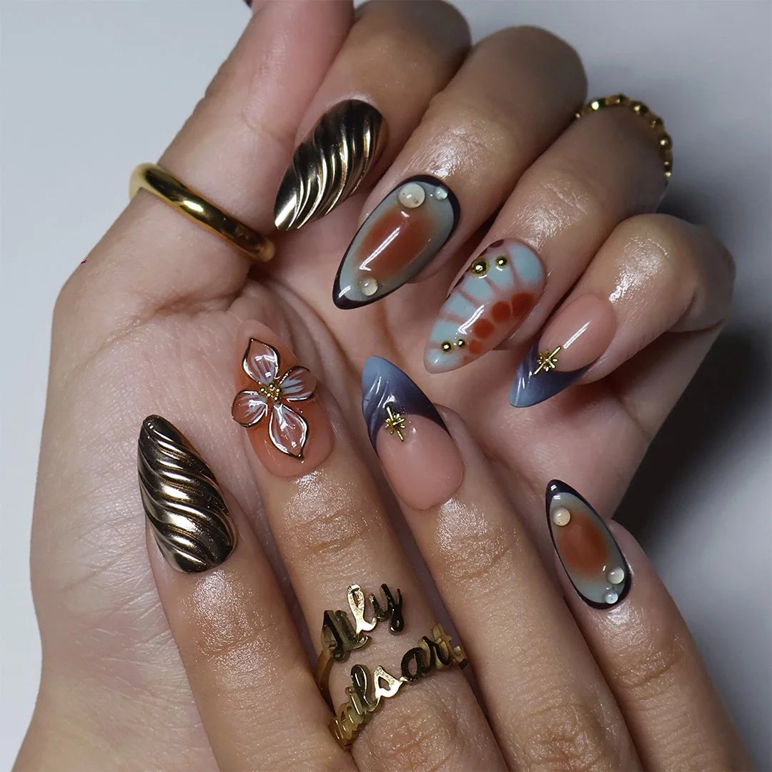 Blue-grey and gold almond press on nails worn on hand