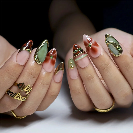 Close-up of hand-painted tortoiseshell and gold gem detail on almond nails