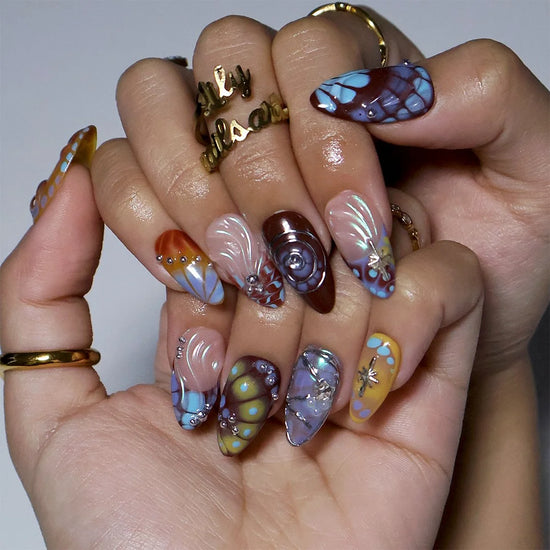 Asteria handmade Y2K press-on nails — almond set in caramel, brown and sky blue with silver chrome swirls, starbursts and marble effects