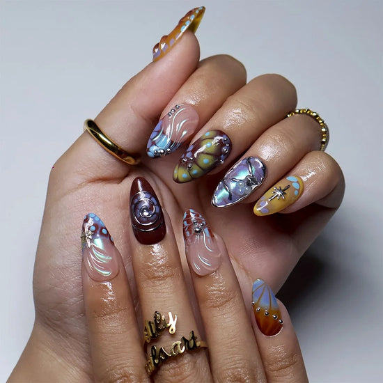 Asteria handmade Y2K press-on nails — almond set in caramel, brown and sky blue with silver chrome swirls, starbursts and marble effects