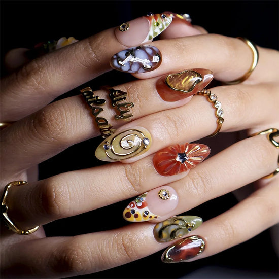 Close-up of marble, agate and starburst gem detail on almond nails