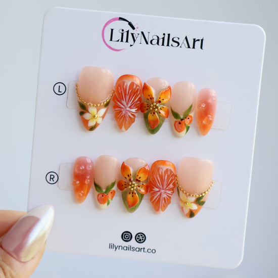 Handmade summer press-on nails with vivid citrus blooms, tropical floral art and gold bead embellishments by Lily Nails Art