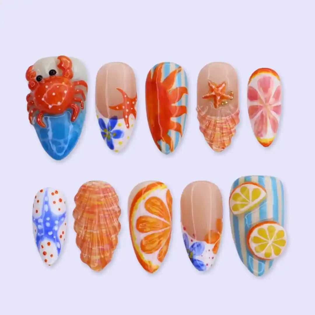 Handmade summer press-on nails with coastal art featuring crabs, starfish, seashells and citrus slices by Lily Nails Art