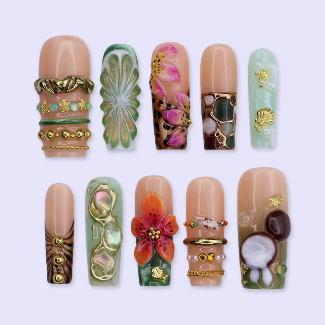 Handmade luxury summer press-on nails with tropical hibiscus, coconut art, 3D floral centerpiece and gold chain embellishments by Lily Nails Art