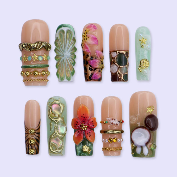 Handmade luxury summer press-on nails with tropical hibiscus, coconut art, 3D floral centerpiece and gold chain embellishments by Lily Nails Art