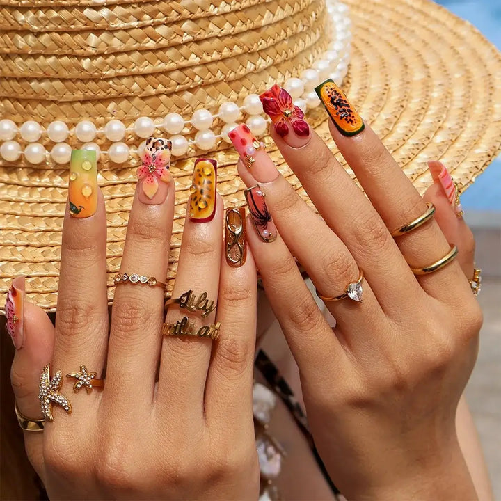 Handmade summer press-on nails with tiger lily blooms, leopard print and tropical fruit art by Lily Nails Art