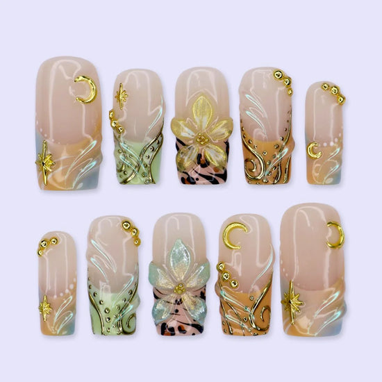 Handmade summer press-on nails with sage green botanical art, leopard print and gold moon and star charm embellishments by Lily Nails Art