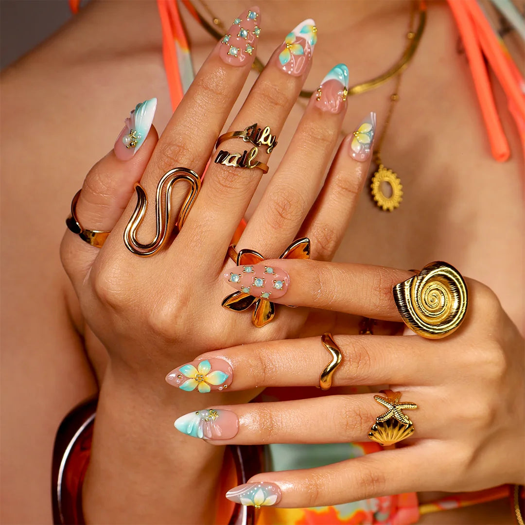 Handmade summer press-on nails with teal aqua tips, hand-painted tropical blooms and gold crystal embellishments by Lily Nails Art