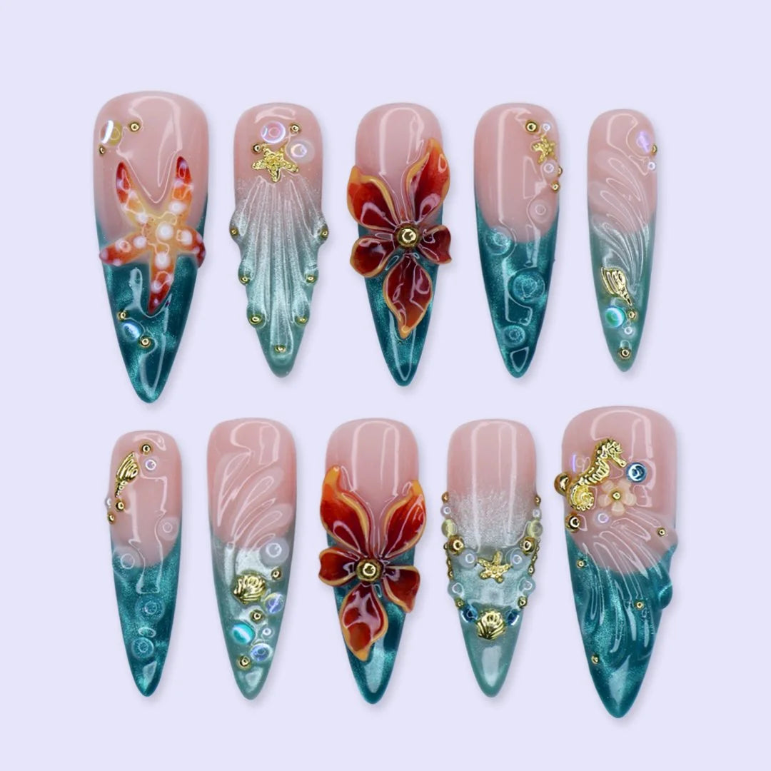 Handmade summer stiletto press-on nails with deep teal ocean base, amber bloom, starfish, gold seahorse charm and iridescent crystal embellishments by Lily Nails Art
