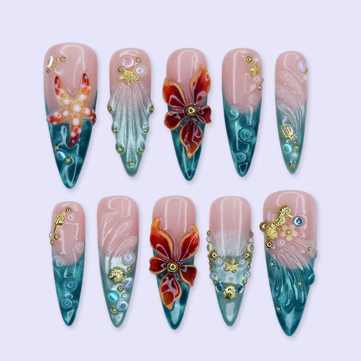 Handmade summer stiletto press-on nails with deep teal ocean base, amber bloom, starfish, gold seahorse charm and iridescent crystal embellishments by Lily Nails Art
