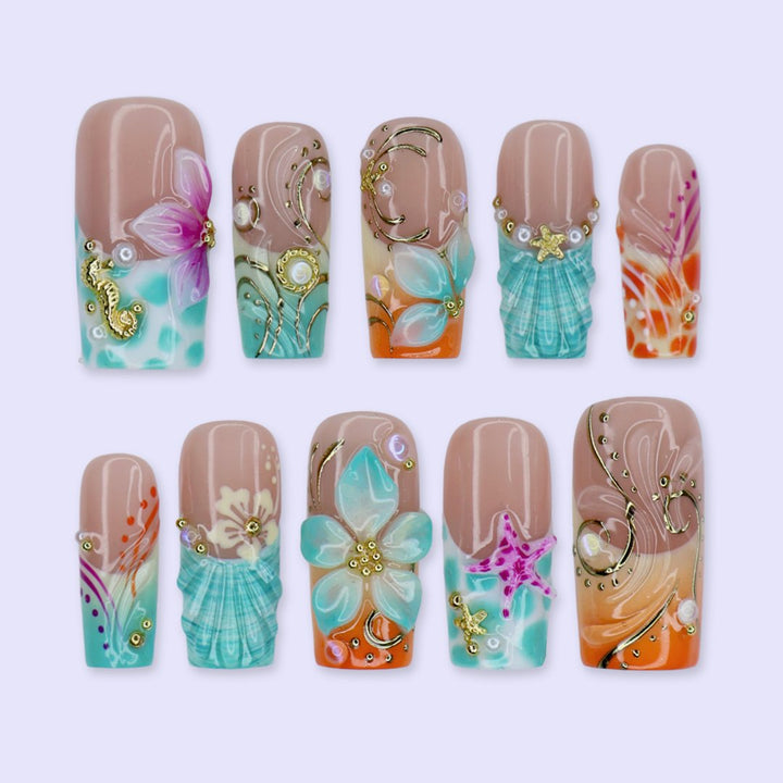 Handmade summer press-on nails with ocean art featuring seahorse, starfish, seashells, teal waves and gold swirl embellishments by Lily Nails Art