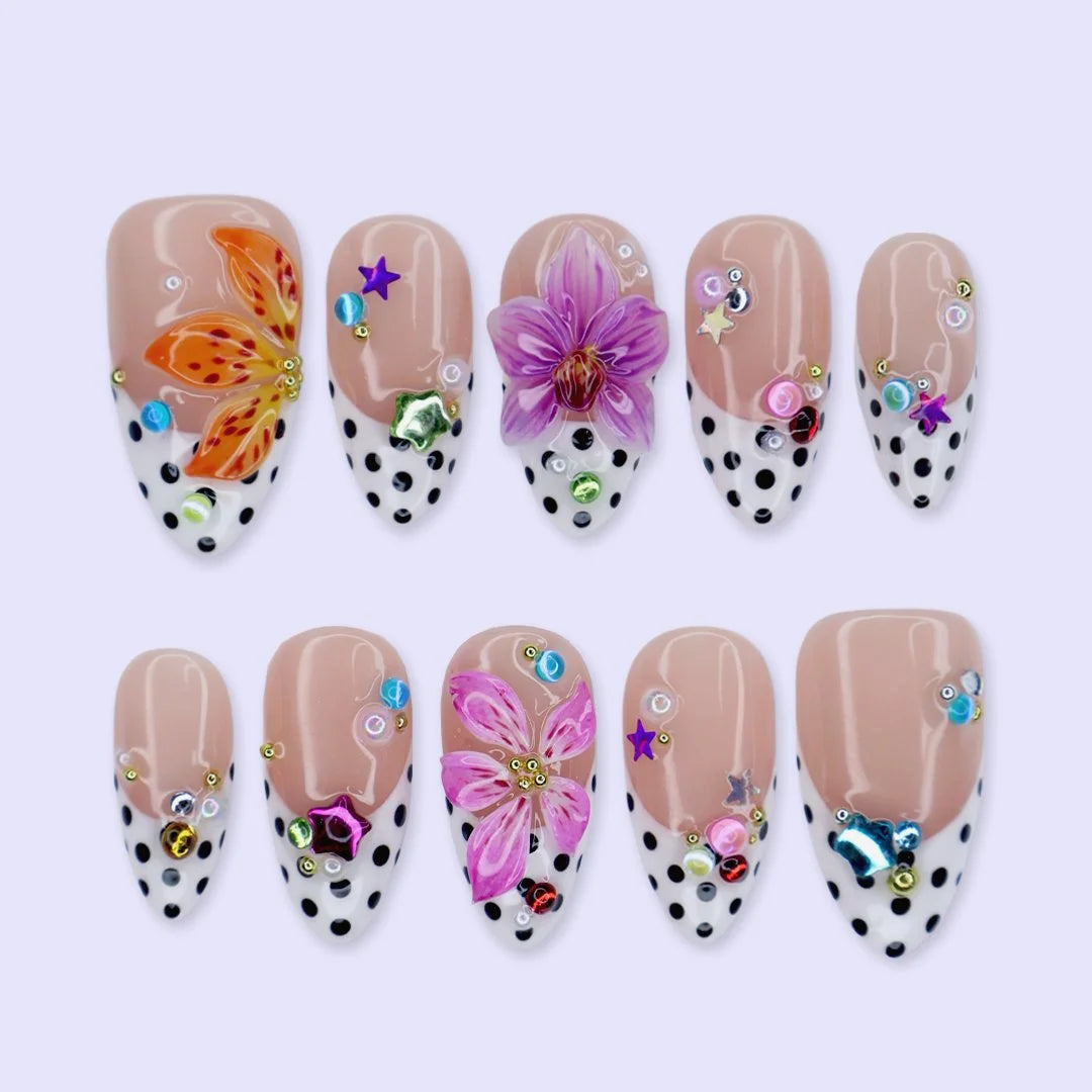 Handmade summer press-on nails with black polka dot French tips, tiger lily, orchid and rainbow gemstone confetti embellishments by Lily Nails Art
