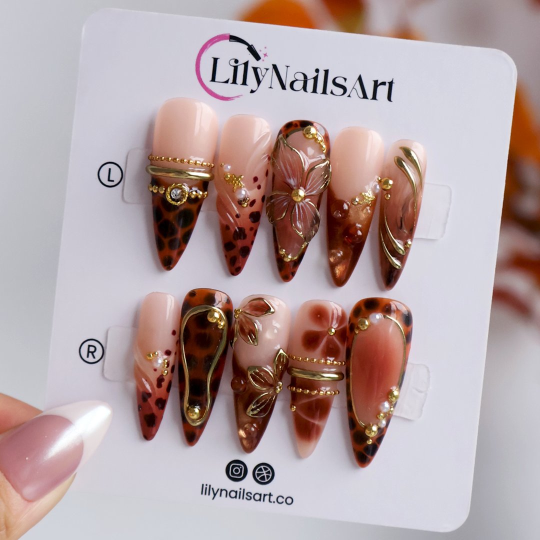 Cognac handmade fall press-on nails — almond set in nude and tortoiseshell brown with gold 3D lilies, wire-work and leopard print