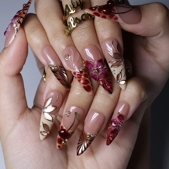Marsala handmade fall press-on nails — long almond set in nude and plum-magenta with 3D lilies, gold cat-eye petals and berry details