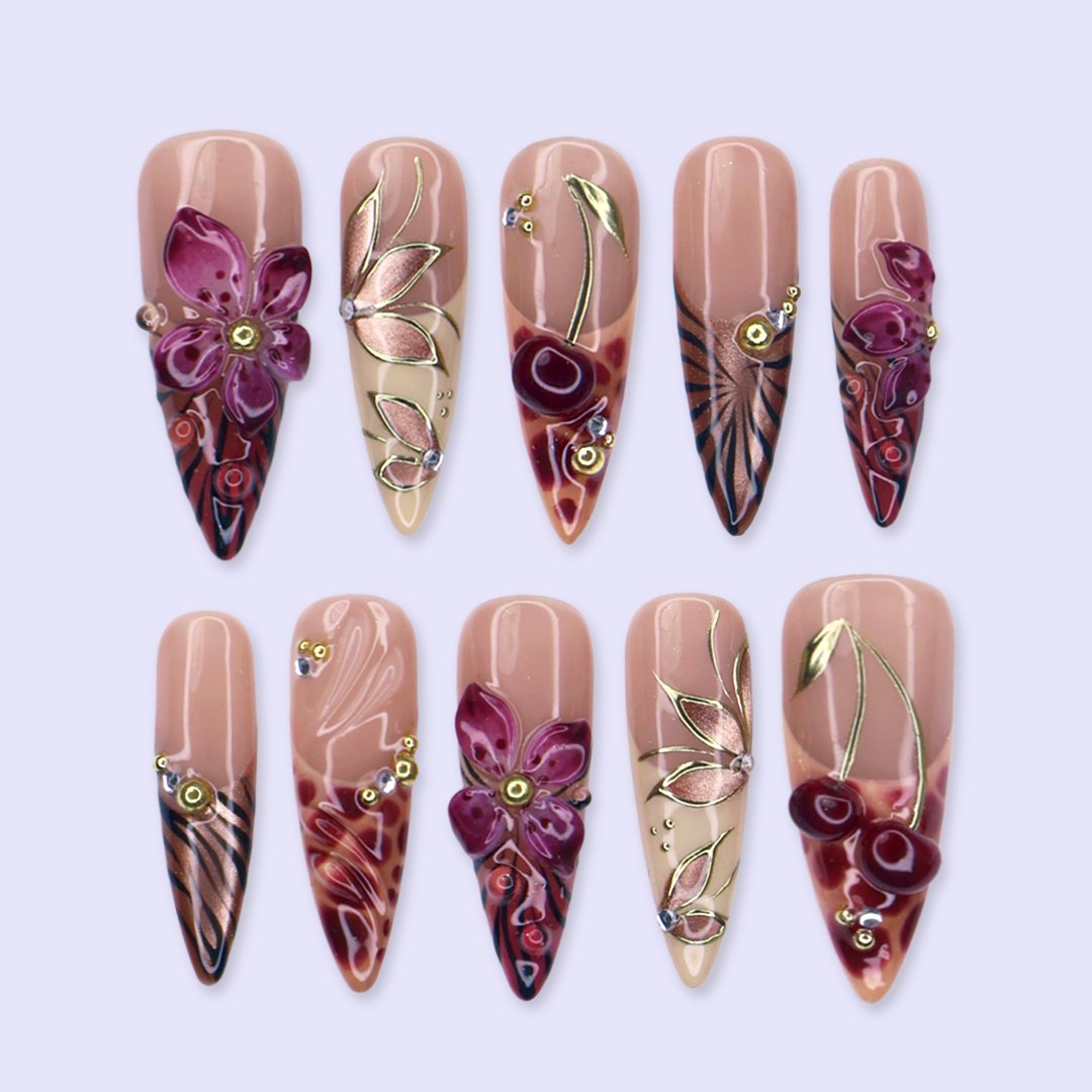 Marsala handmade fall press-on nails — long almond set in nude and plum-magenta with 3D lilies, gold cat-eye petals and berry details