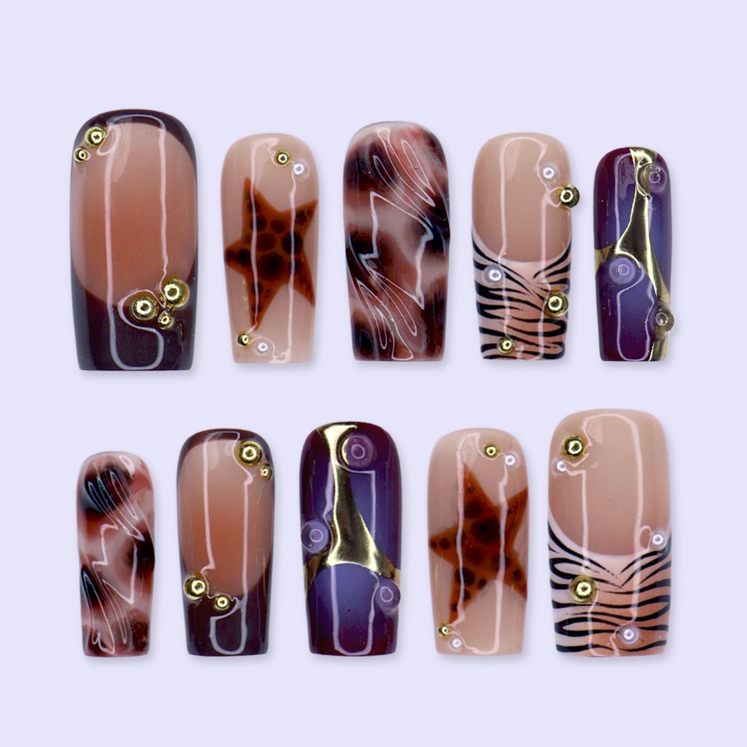 Stargazer handmade fall press-on nails — medium square set in nude, plum-purple and brown with tortoiseshell stars, gold accents and zebra-stripe tips
