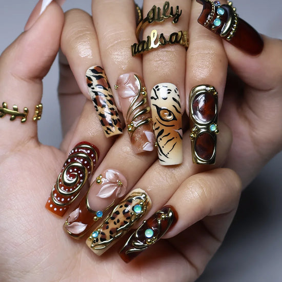 Safari handmade fall press-on nails — long square set in nude, caramel and amber with leopard, tiger print, gold swirls and gems