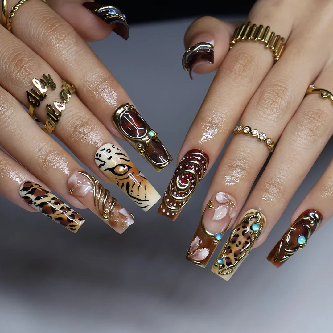 Safari handmade fall press-on nails — long square set in nude, caramel and amber with leopard, tiger print, gold swirls and gems