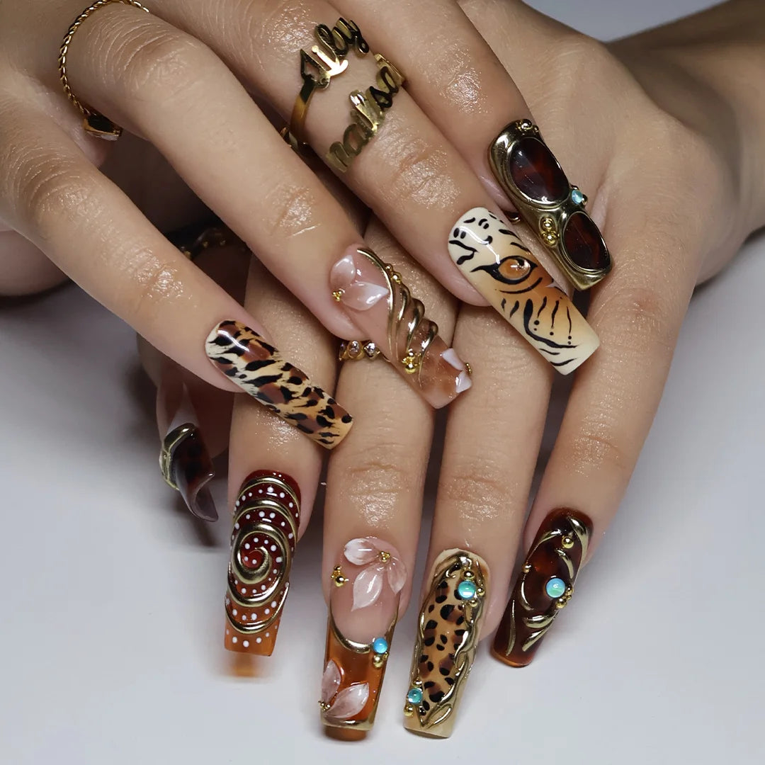 Safari handmade fall press-on nails — long square set in nude, caramel and amber with leopard, tiger print, gold swirls and gems