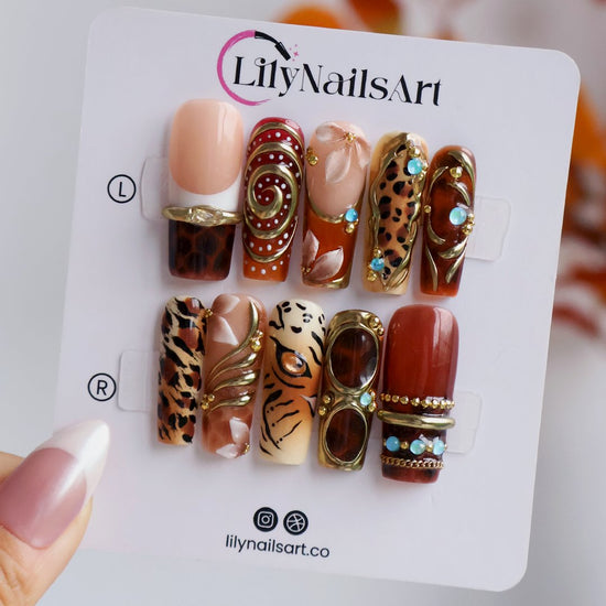 Safari handmade fall press-on nails — long square set in nude, caramel and amber with leopard, tiger print, gold swirls and gems