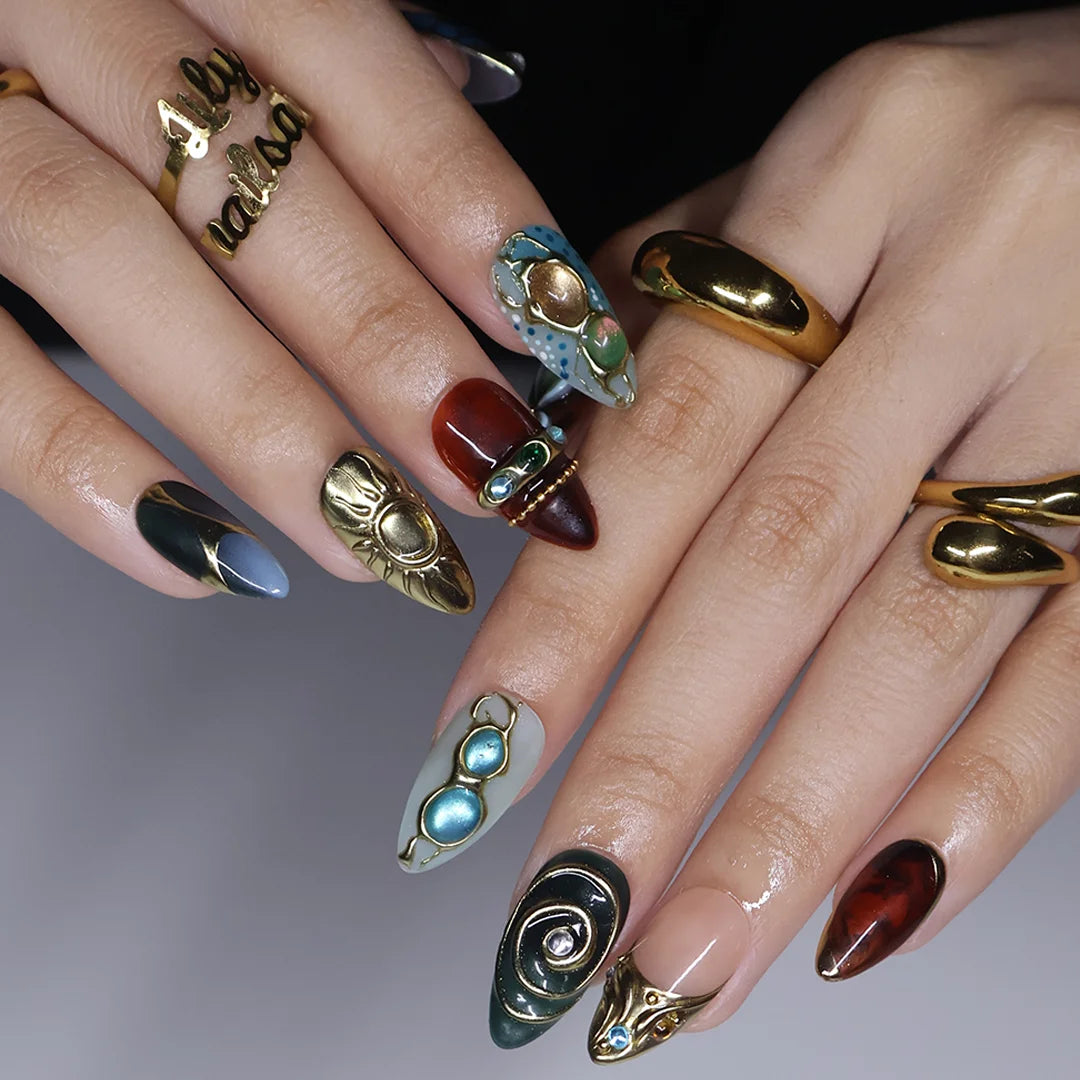 Solstice handmade maximalist press-on nails — almond set in teal, sage, rust and navy with a sculpted gold sun, 3D flower and jewel cabochons