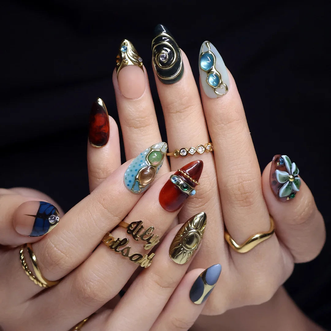 Solstice handmade maximalist press-on nails — almond set in teal, sage, rust and navy with a sculpted gold sun, 3D flower and jewel cabochons