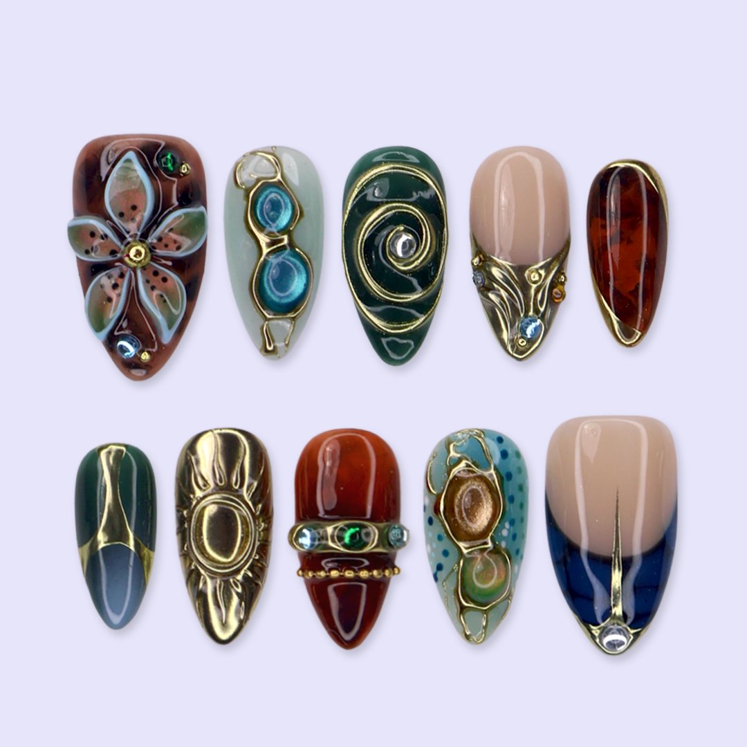 Solstice handmade maximalist press-on nails — almond set in teal, sage, rust and navy with a sculpted gold sun, 3D flower and jewel cabochons