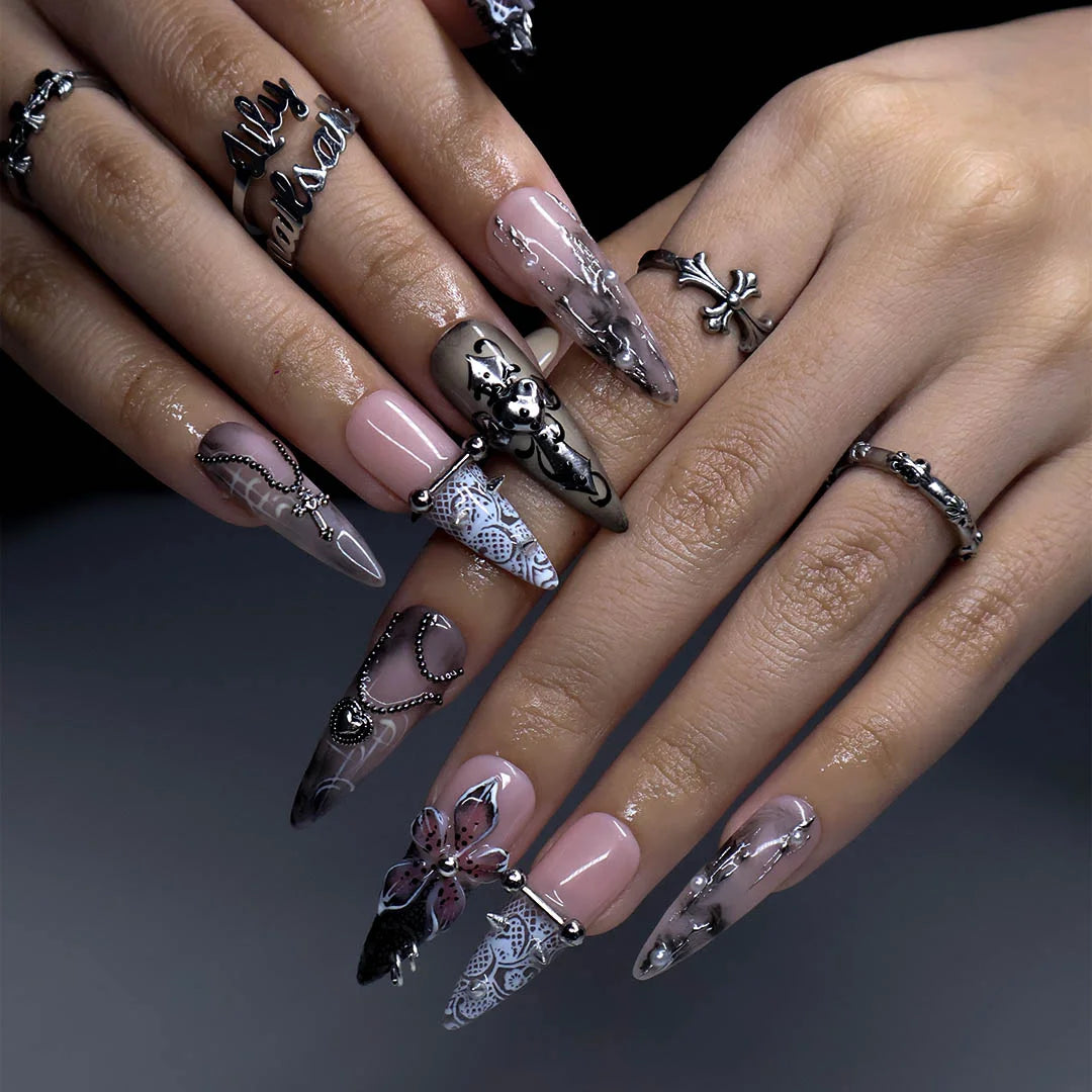 Gothic press on nails in black and nude with 3D crosses, silver metallic details and dark crystal embellishments — handmade Halloween press on nails, long almond fake nails and gothic nail art.