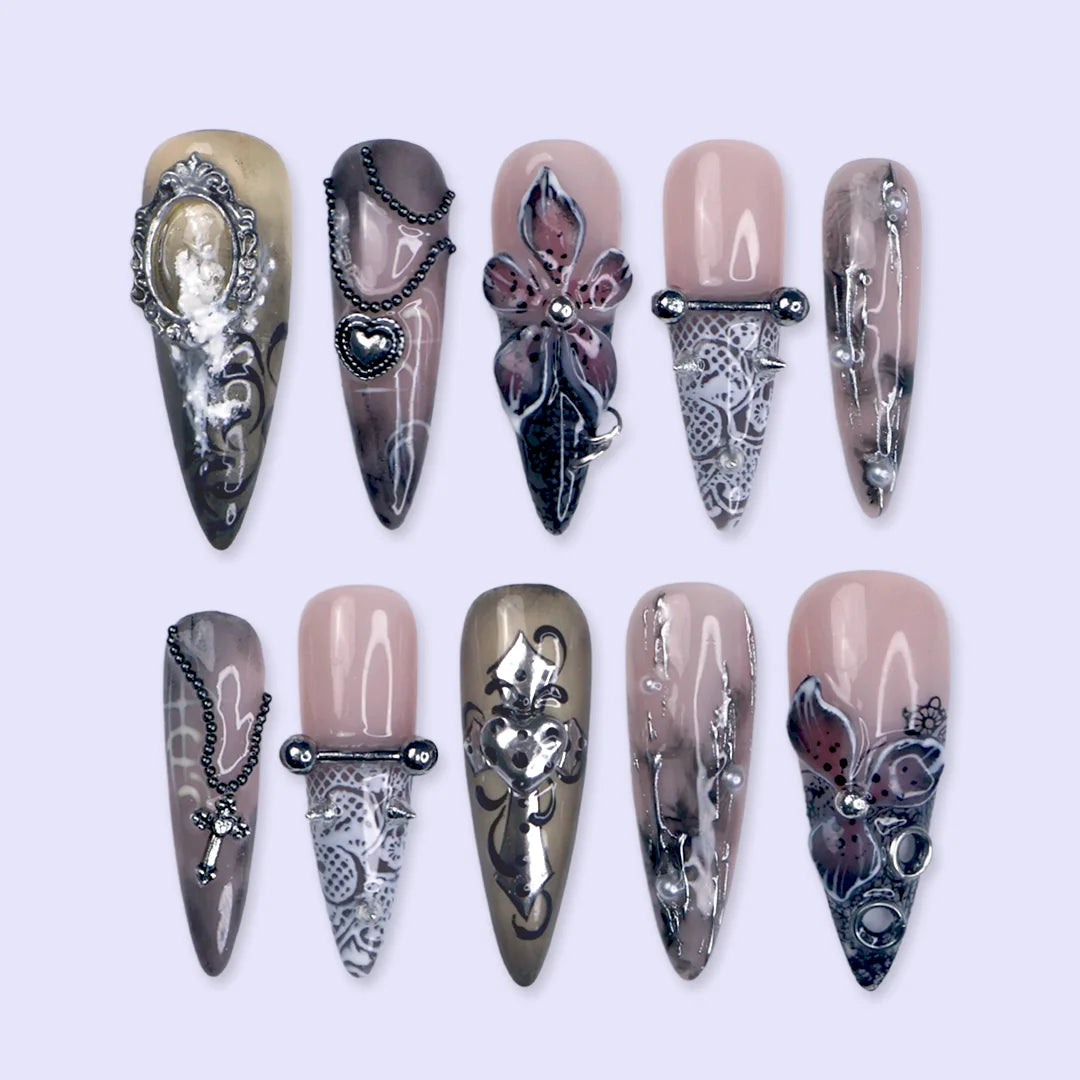 Gothic press on nails in black and nude with 3D crosses, silver metallic details and dark crystal embellishments — handmade Halloween press on nails, long almond fake nails and gothic nail art.