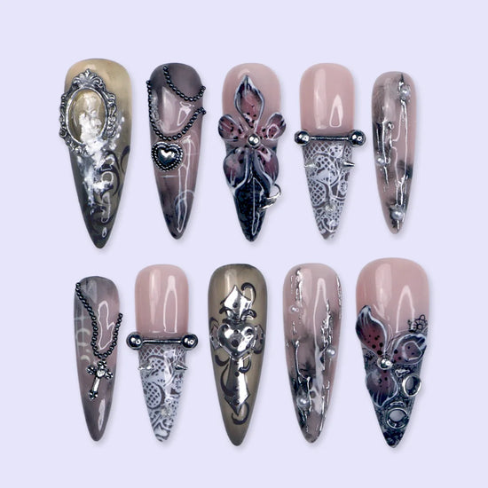 Gothic press on nails in black and nude with 3D crosses, silver metallic details and dark crystal embellishments — handmade Halloween press on nails, long almond fake nails and gothic nail art.