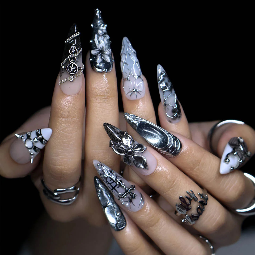 Grimoire gothic press on nails in black, chrome and grey with silver crosses, chains, snake, spiderweb details and 3D silver lilies — handmade Halloween press on nails, long almond fake nails and gothic nail art.