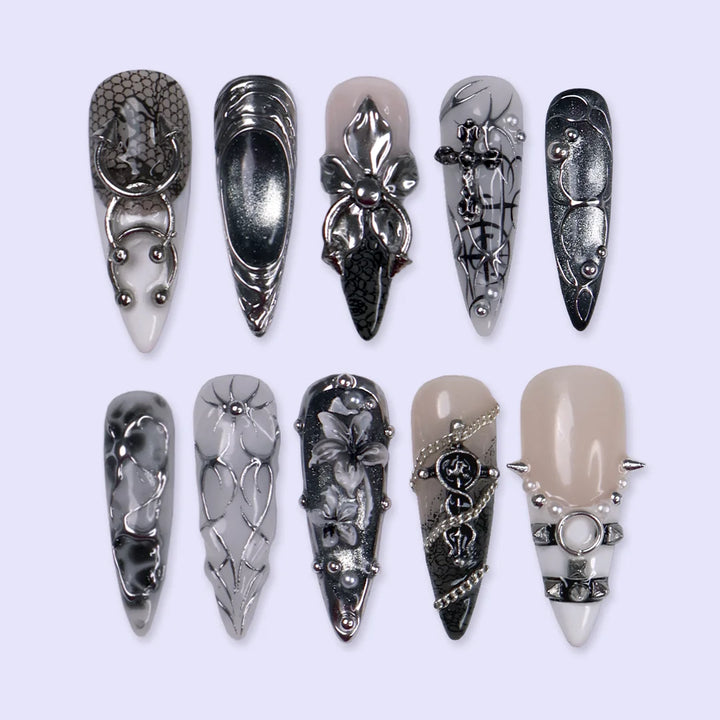 Grimoire gothic press on nails in black, chrome and grey with silver crosses, chains, snake, spiderweb details and 3D silver lilies — handmade Halloween press on nails, long almond fake nails and gothic nail art.