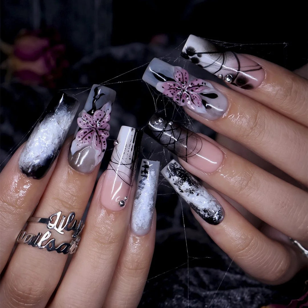 Belladonna gothic press on nails in smoky black and grey over nude with abstract ink marbling, delicate linework and 3D mauve-pink lilies — handmade Halloween press on nails, long square fake nails and gothic nail art.