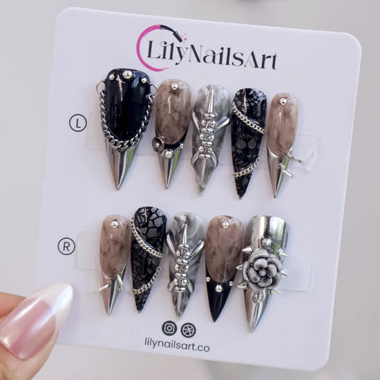 Vanquish gothic press on nails in black, smoky marble and taupe with chrome dagger tips, spikes, chains, black lace, metallic studs and a 3D grey rose — handmade Halloween press on nails, long stiletto fake nails and gothic nail art.