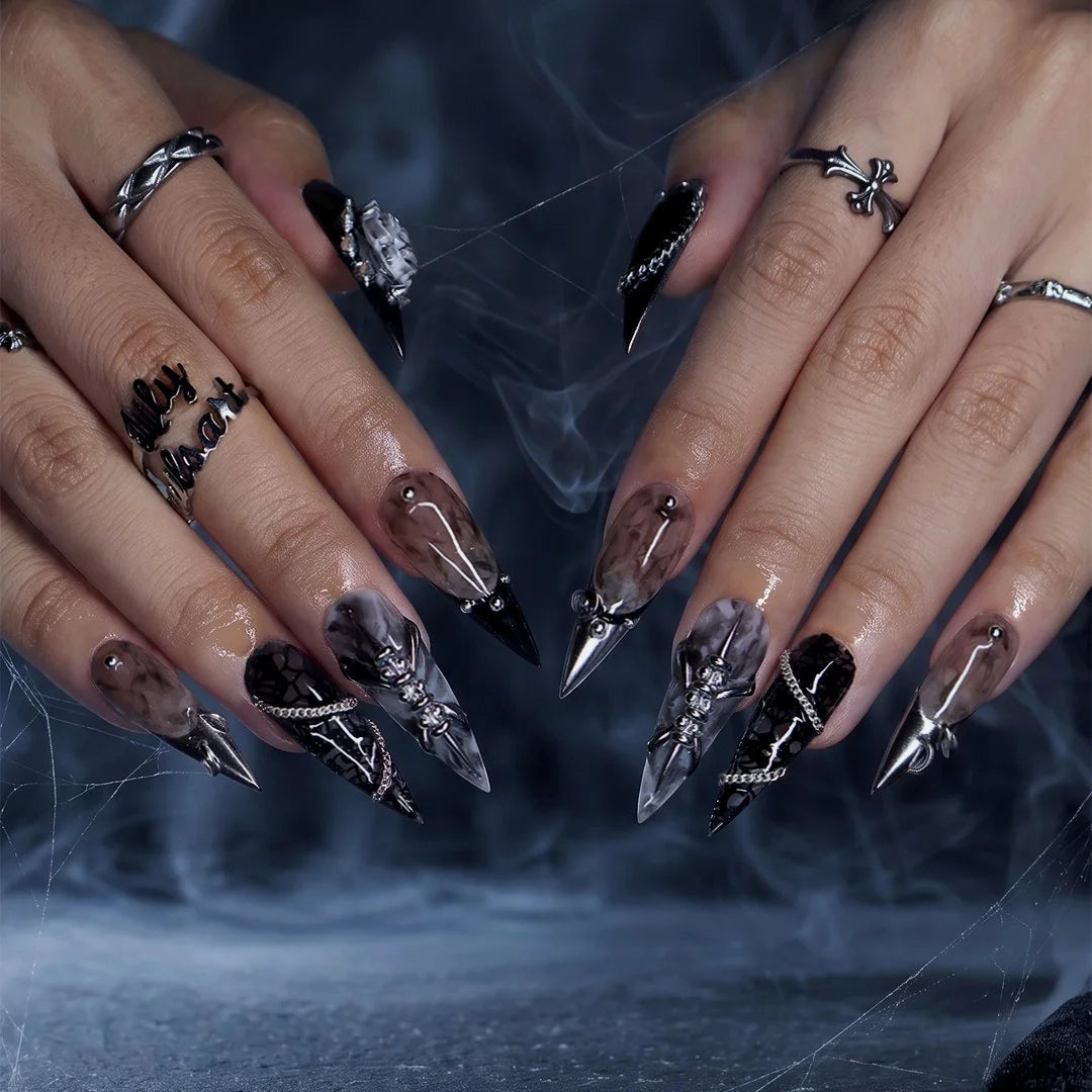 Vanquish gothic press on nails in black, smoky marble and taupe with chrome dagger tips, spikes, chains, black lace, metallic studs and a 3D grey rose — handmade Halloween press on nails, long stiletto fake nails and gothic nail art.