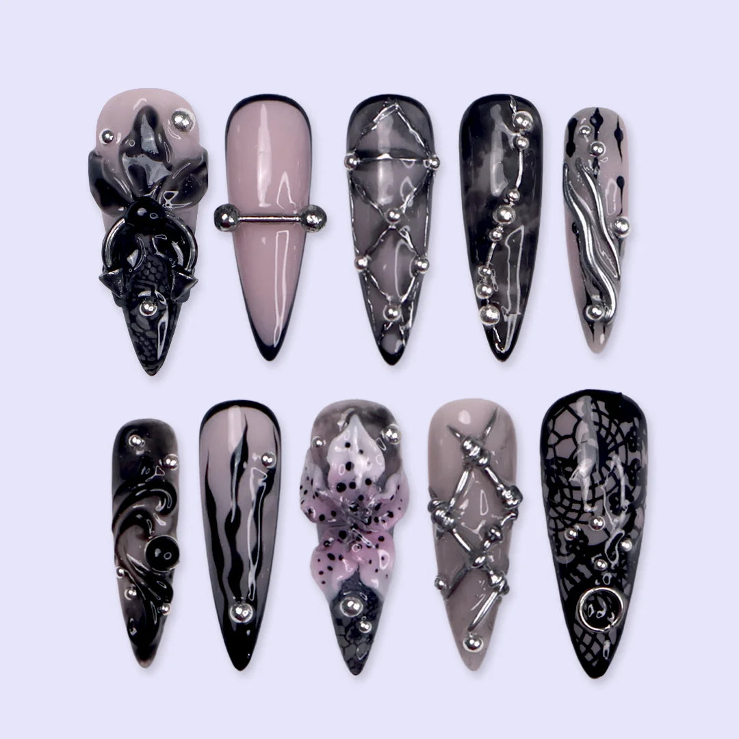 Enigma gothic press on nails in smoky mauve-grey, black and nude with silver piercings, chain lattice, black lace, baroque swirls and a 3D purple lily — handmade Halloween press on nails, long stiletto fake nails and gothic nail art.