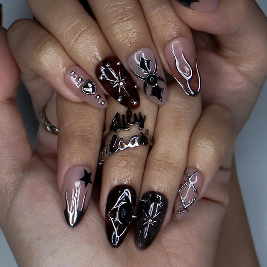 Séance gothic press on nails in nude, tortoiseshell brown and black with chrome silver flames, a 3D spider, ornate cameo, stars, heart charm and stitched details — handmade Halloween press on nails, medium almond fake nails and occult gothic nail art.
