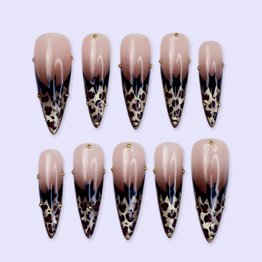 Prowl fall press on nails in nude with black and gold leopard-print French tips and delicate gold bead accents — handmade designer press on nails, long almond fake nails and animal print nail art.