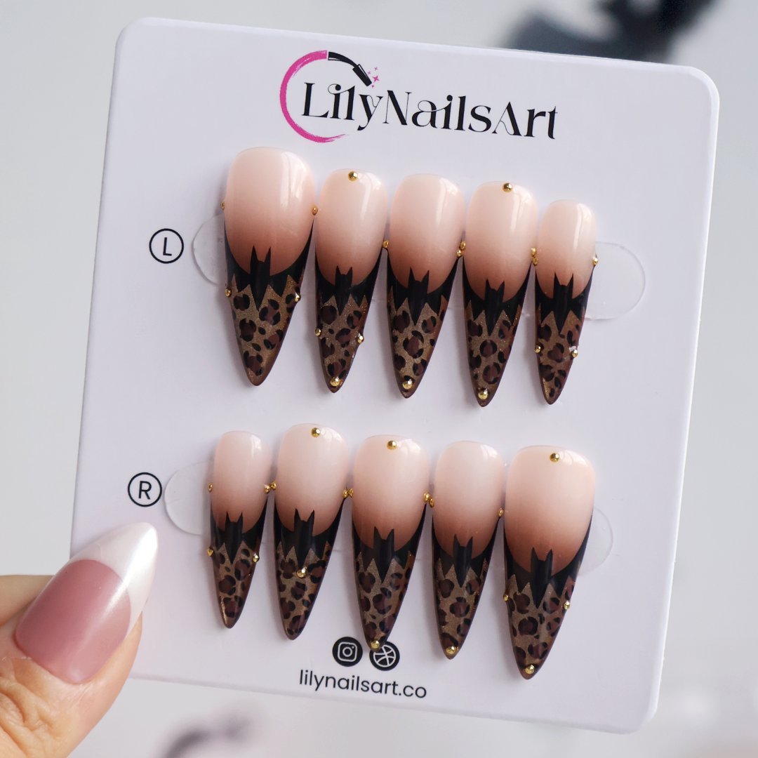 Prowl fall press on nails in nude with black and gold leopard-print French tips and delicate gold bead accents — handmade designer press on nails, long almond fake nails and animal print nail art.