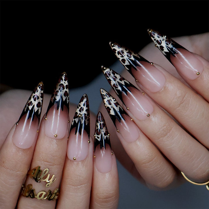 Prowl fall press on nails in nude with black and gold leopard-print French tips and delicate gold bead accents — handmade designer press on nails, long almond fake nails and animal print nail art.