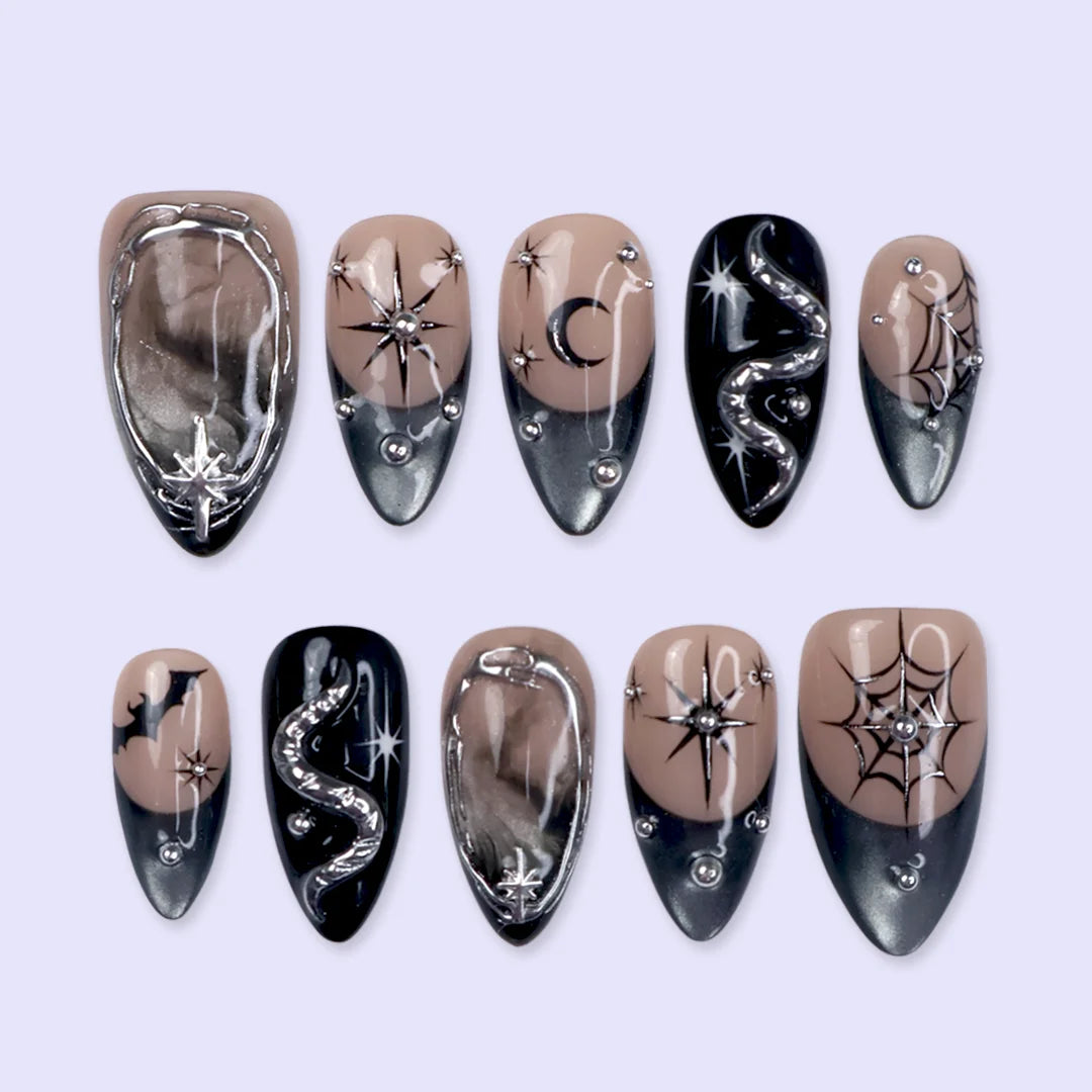 Eclipse gothic Halloween press on nails in nude, smoky black and silver chrome with a 3D snake, spiderwebs, bat, stars and crescent moon — handmade designer press on nails, medium almond fake nails and celestial witchy nail art.