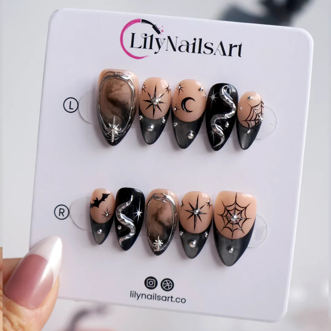 Eclipse gothic Halloween press on nails in nude, smoky black and silver chrome with a 3D snake, spiderwebs, bat, stars and crescent moon — handmade designer press on nails, medium almond fake nails and celestial witchy nail art.