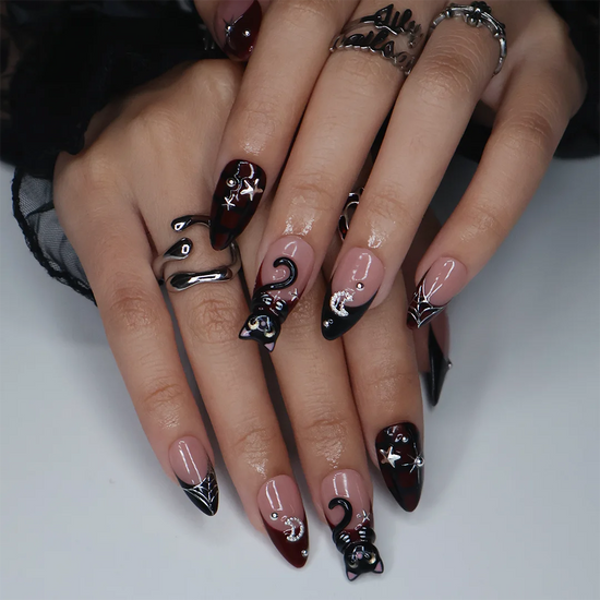 Meow gothic Halloween press on nails in nude, dark red and black with adorable 3D black cats, rhinestone moons, silver stars, spiderwebs and plaid accents — handmade designer press on nails, medium almond fake nails and cute witchy nail art.