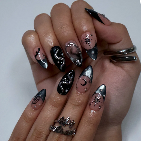 Eclipse gothic Halloween press on nails in nude, smoky black and silver chrome with a 3D snake, spiderwebs, bat, stars and crescent moon — handmade designer press on nails, medium almond fake nails and celestial witchy nail art.